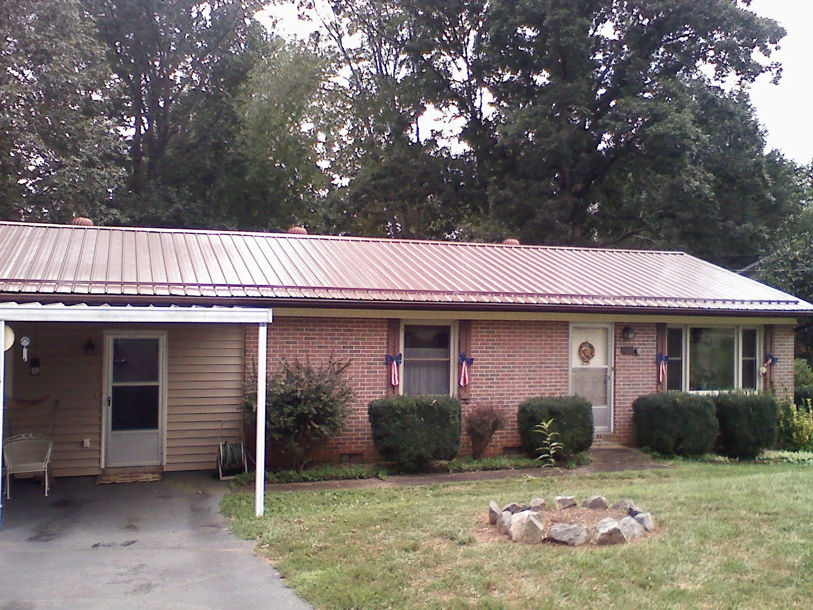 Bronze metal roof and carport on a brick ranch home — Roof Repair work by our crew in Preston Hollow