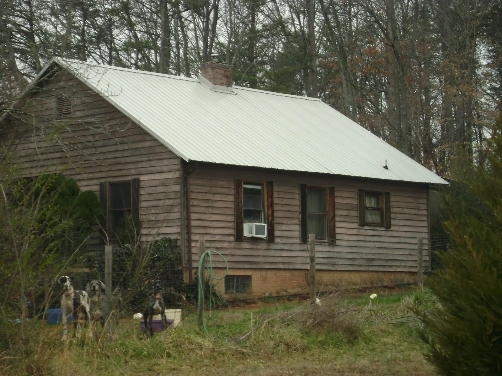 White metal roof on an old wood sided farmhouse, from a Asphalt Shingle Roof Repair job in Preston Hollow